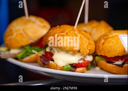 Typischer Mini-Burger-Snack aus dem Baskenland, Pinchos oder Pinxtos, kleines Stück Brot mit verschiedenen Belägen, serviert in der Bar in San-Sebastian oder Bilba Stockfoto