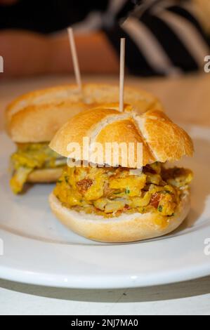 Typischer Mini-Burger-Snack aus dem Baskenland, Pinchos oder Pinxtos, kleines Stück Brot mit verschiedenen Belägen, serviert in der Bar in San-Sebastian oder Bilba Stockfoto
