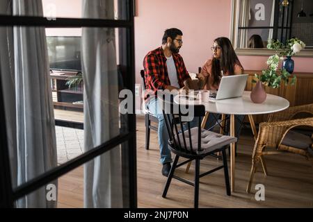 Ernsthafte Ehefrau und Ehemann planen Budget, prüfen Finanzen, fokussierte junge Frau mit Online-Rechner und Zählen von Rechnungen oder Steuern, Mann mit Laptop Stockfoto