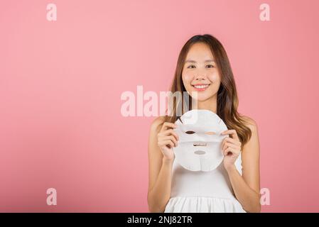 Asiatische Frau, die eine reinigende Maske an den Händen hält Stockfoto