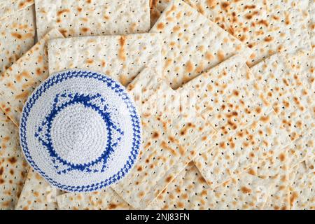 Das Konzept der Pessachstunde. Weiße Kippah mit David-Stern auf Matzah-Texturhintergrund. Essen im Pessar. Jüdischer Feiertag in Pesach. Traditionelles Ritual J Stockfoto