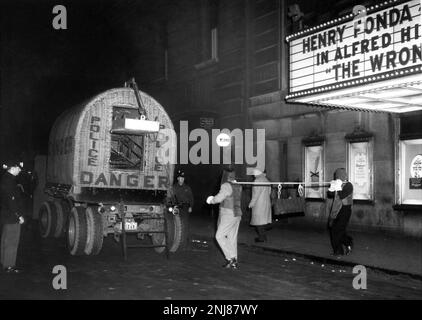 Polizeibeamte entfernen Bombe aus dem New York Paramount Theatre am frühen Morgen des 28. Dezember 1956, als das Kino HENRY FONDA in THE WRONG MAN 1956 Regisseur ALFRED HITCHCOCK für Warner Bros. Zeigte Stockfoto