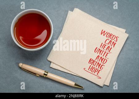 Worte können heilen, sich vereinen und Hoffnung bringen. Inspirierende Handschrift auf Serviette, Macht der Wörter und Kommunikationskonzept. Stockfoto