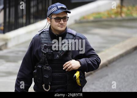 England, London, Westminster, Downing Street, AFO Polizist trägt Körperschutz und Baseballmütze. Stockfoto