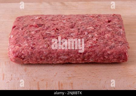 Rolata aus rohem Hackfleisch auf einem Holzschneidbrett, ideal zum Füllen Stockfoto