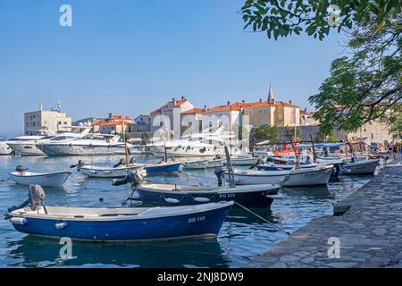 Kleine Fischerboote und Motoryachten im Yachthafen nördlich der Stadtmauern der Altstadt von Budva entlang der Adria, Montenegro Stockfoto