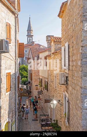 Touristen wandern in der engen Gasse der venezianischen Altstadt Budua in der mittelalterlichen Stadt Budva entlang der Adria, Montenegro Stockfoto