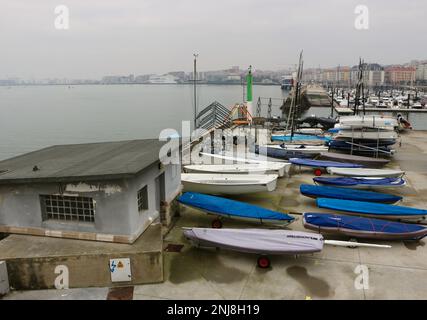 Segelschule mit Dingis aus dem Wasser und Blick über die Bucht mit einer Fähre der Bretagne Ferries in der Ferne Santander Cantabria Spanien Stockfoto