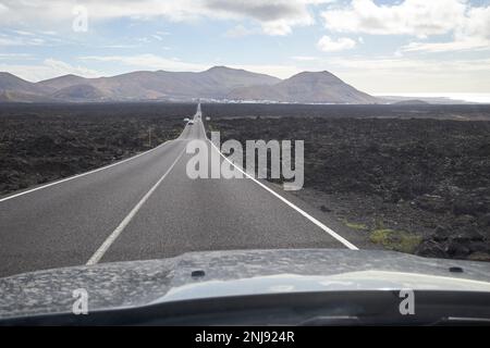 Fahrt auf der Straße durch Lavafelder im südlichen Teil von Lanzarote, Teil des timanfaya Nationalparks, Kanarische Inseln, Spanien Stockfoto