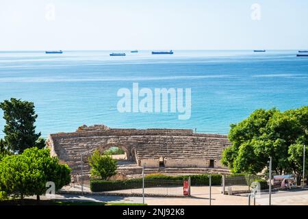 TARRAGONA, SPANIEN - 6. AUGUST 2022: Weitwinkelblick auf die Ruinen des römischen Amphitheaters in Tarragona, erbaut im 2. Jahrhundert v. Chr., mit dem Mediterr Stockfoto