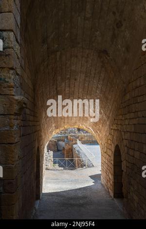 Tunnelblick auf die Ruinen des römischen Amphitheaters in Tarragona, erbaut im 2. Jahrhundert v. Chr., mit dem Mittelmeer im Hintergrund. Stockfoto