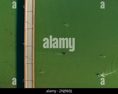 Luftaufnahme der Brücke über den Segre in Mequinenza und Kajaks und Boote, die auf dem Fluss segeln (Bajo Cinca, Saragoza, Aragon, Spanien) Stockfoto