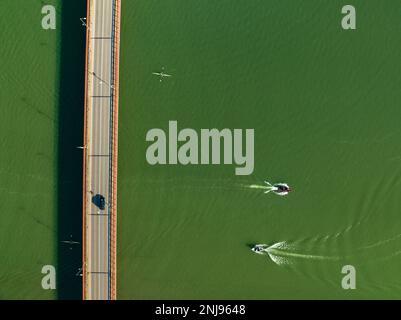 Luftaufnahme der Brücke über den Segre in Mequinenza und Kajaks und Boote, die auf dem Fluss segeln (Bajo Cinca, Saragoza, Aragon, Spanien) Stockfoto