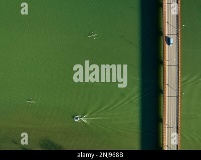 Luftaufnahme der Brücke über den Segre in Mequinenza und Kajaks und Boote, die auf dem Fluss segeln (Bajo Cinca, Saragoza, Aragon, Spanien) Stockfoto