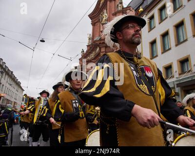 Würzburg, Bayern, 19. Februar 2023. Männer und Frauen in alten Kostümen mit Schlagzeug auf der Karnevalsparade (Fasching) Stockfoto