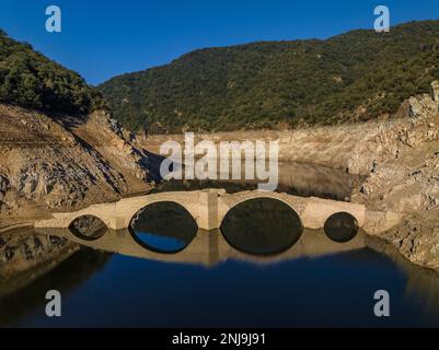 Luftaufnahme der mittelalterlichen Brücke von Querós, im Susqueda-Reservoir, sichtbar während einer Dürre mit 36 % Wasserstand (Katalonien, Spanien) Stockfoto