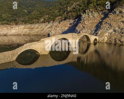 Luftaufnahme der mittelalterlichen Brücke von Querós, im Susqueda-Reservoir, sichtbar während einer Dürre mit 36 % Wasserstand (Katalonien, Spanien) Stockfoto