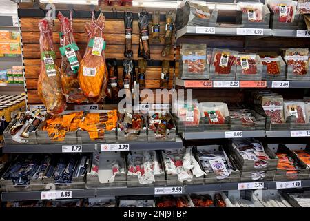 Regale im Supermarkt mit Päckchen haltbar gemachtem Räucherfleisch, Salami, Chorizo, Speck, Schinken, Würstchen Stockfoto