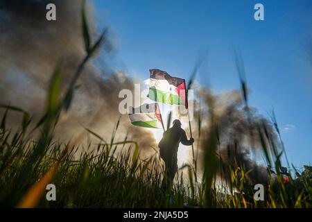 Gaza. 22. Februar 2023. Ein Mann protestiert nach der Ermordung von 10 Palästinensern durch israelische Streitkräfte, nahe der Grenze zwischen Gaza und Israel, östlich von Gaza-Stadt, am 22. Februar 2023. Die Palästinenser verurteilten am Mittwoch die Ermordung von 10 Palästinensern und die Verwundung von 102 weiteren während eines israelischen Überfalls im nördlichen Westjordanland von Nablus. Kredit: Rizek Abdeljawad/Xinhua/Alamy Live News Stockfoto