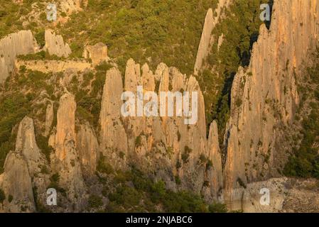 Details der Roques de la Vila in Finestres (auch bekannt als Muralla de Finestres) und der Einsiedlung von San Vicente zwischen den Felsen bei Sonnenuntergang, Spanien Stockfoto