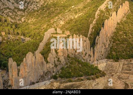 Details der Roques de la Vila in Finestres (auch bekannt als Muralla de Finestres) und der Einsiedlung von San Vicente zwischen den Felsen bei Sonnenuntergang, Spanien Stockfoto