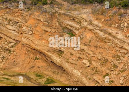 Details der Erosion mit Felsen und Erde im Inneren des Canelles Reservoirs mit niedrigem Wasserstand (Ribagorza, Huesca, Aragon, Spanien) Stockfoto