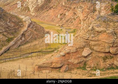 Details der Erosion mit Felsen und Erde im Inneren des Canelles Reservoirs mit niedrigem Wasserstand (Ribagorza, Huesca, Aragon, Spanien) Stockfoto