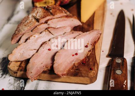 Eine Nahaufnahme frisch zubereiteter Fleisch- und Käsescheiben auf einem Schneidebrett Stockfoto