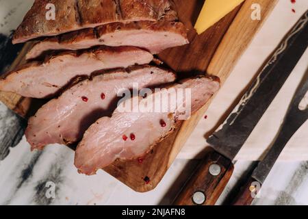 Eine Nahaufnahme frisch zubereiteter Fleisch- und Käsescheiben auf einem Schneidebrett Stockfoto
