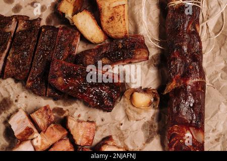 Zwei saftige Schweinerippchen mit kleinen Fleischstücken und eine Kartoffel auf einem Teller, bereit zum Genießen Stockfoto