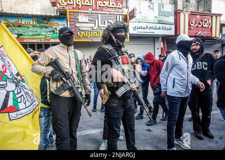 Nablus, Palästina. 22. Februar 2023. Palästinensische Schützen nehmen an der Beerdigung von zehn Palästinensern Teil, die bei einem Überfall auf die Stadt Nablus im besetzten Westjordanland mit israelischen Armeekugeln getötet wurden. Die israelische Armee brach in den Unterschlupf ein, in dem sich palästinensische Schützen aus den Lions' Den-Gruppen in der Altstadt von Nablus versteckten, und tötete vier Schützen und sechs Zivilisten, die während dieser Razzia auf dem Markt waren. Kredit: SOPA Images Limited/Alamy Live News Stockfoto