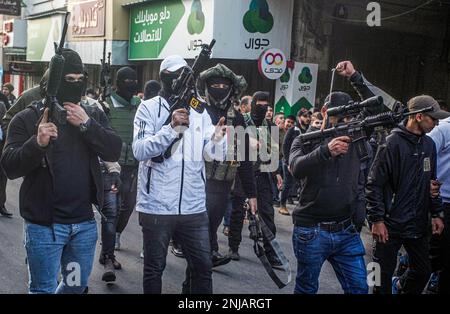 Nablus, Palästina. 22. Februar 2023. Palästinensische Schützen nehmen an der Beerdigung von zehn Palästinensern Teil, die bei einem Überfall auf die Stadt Nablus im besetzten Westjordanland mit israelischen Armeekugeln getötet wurden. Die israelische Armee brach in den Unterschlupf ein, in dem sich palästinensische Schützen aus den Lions' Den-Gruppen in der Altstadt von Nablus versteckten, und tötete vier Schützen und sechs Zivilisten, die während dieser Razzia auf dem Markt waren. Kredit: SOPA Images Limited/Alamy Live News Stockfoto