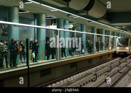 Personen, die auf einen Zug hinter automatischen vertikalen Bahnsteig-Windschranken warten, die als Vorbeugungs- und Sicherheitsmaßnahme für die Passagiere nach oben klappen. Blick auf U-Bahn-, U-Bahn- oder U-Bahn-Station in Sofia, Bulgarien, Osteuropa, Balkan, EU Stockfoto