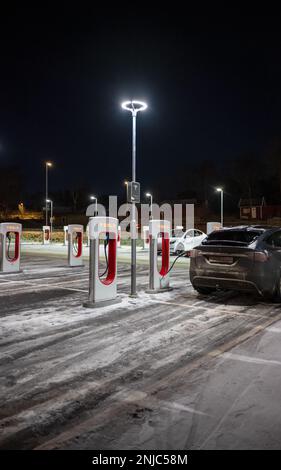 Göteborg, Schweden - dezember 09 2022: Autos laden nachts an Tesla Supercharger auf Stockfoto