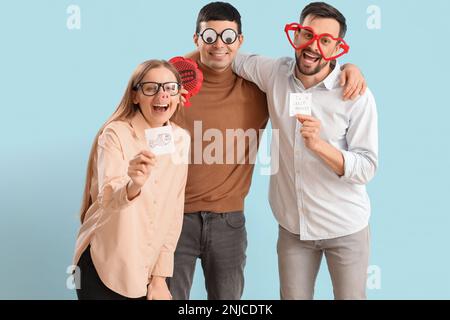 Geschäftskollegen in lustiger Verkleidung auf blauem Hintergrund. Feier zum 1. April Stockfoto