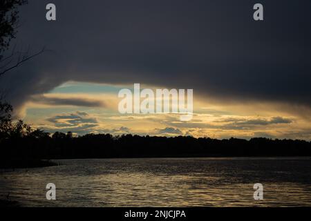 Gewitterwolken bei Sonnenuntergang über dem Dnieper River Stockfoto