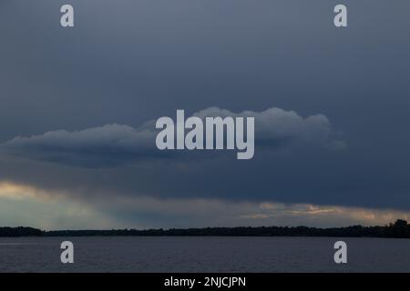 Gewitterwolken bei Sonnenuntergang über dem Dnieper River Stockfoto