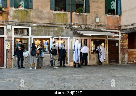 Orthodoxe juden und Touristen vor dem Venedig Chabad House in Campo del Ghetto Nuovo (Platz des Neuen Ghettos) im Sestiere von Cannaregio, Venedig, Italien Stockfoto