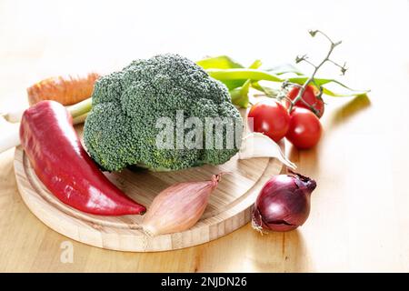 Frisches Gemüse wie Brokkoli, Paprika, Zwiebeln und mehr auf einem Holzbrett, Zutaten für gesundes Kochen, Kopierraum, ausgewählter Fokus, n Stockfoto