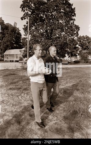 1976 demokratischer Präsidentschaftskandidat Jimmy Carter auf seiner Farm in Plains, GA. Carter spricht mit dem ehemaligen Astronauten und US-Senator John Glenn über die Möglichkeit, dass Glenn Carters stellvertretender Präsidentschaftskandidat wird. Carter und Glenn treffen sich mit Carter Afroamerikaner Bauer Leonard Wright und seiner Tochter. Stockfoto