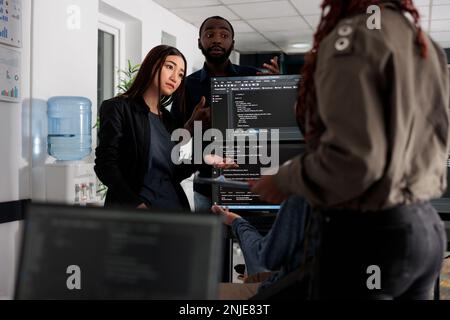 Softwareentwickler arbeiten gemeinsam an einem Programmierprojekt, das über Programmieralgorithmen für die neue Cloud-Computing-Benutzeroberfläche spricht. Ein vielseitiges Team von Webentwicklern, das den Systemcode der Datenbank ausführt. Stockfoto