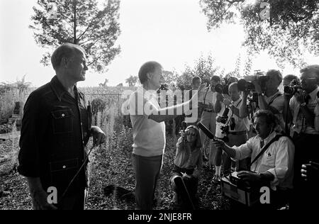 1976 demokratischer Präsidentschaftskandidat Jimmy Carter auf seiner Farm in Plains, GA. Carter spricht mit dem ehemaligen Astronauten und US-Senator John Glenn über die Möglichkeit, dass Glenn Carters stellvertretender Präsidentschaftskandidat wird. Carter und Glenn treffen sich mit Carter Afroamerikaner Bauer Leonard Wright und seiner Tochter. Stockfoto