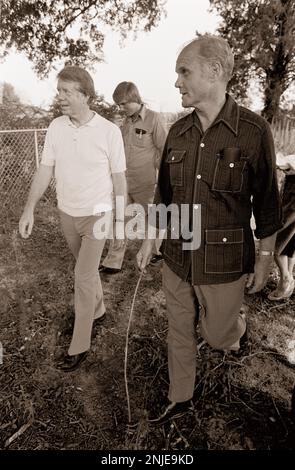 1976 demokratischer Präsidentschaftskandidat Jimmy Carter auf seiner Farm in Plains, GA. Carter spricht mit dem ehemaligen Astronauten und US-Senator John Glenn über die Möglichkeit, dass Glenn Carters stellvertretender Präsidentschaftskandidat wird. Carter und Glenn treffen sich mit Carter Afroamerikaner Bauer Leonard Wright und seiner Tochter. Stockfoto