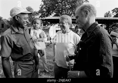 1976 demokratischer Präsidentschaftskandidat Jimmy Carter auf seiner Farm in Plains, GA. Carter spricht mit dem ehemaligen Astronauten und US-Senator John Glenn über die Möglichkeit, dass Glenn Carters stellvertretender Präsidentschaftskandidat wird. Carter und Glenn treffen sich mit Carter Afroamerikaner Bauer Leonard Wright und seiner Tochter. Stockfoto