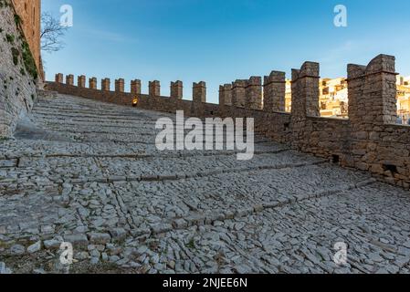 Zinnen verzierte Mauern der Burg Caccamo mit dem Dorf im Hintergrund, Sizilien Stockfoto