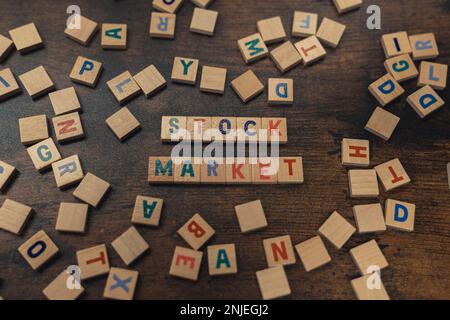 Die Börse wurde mit Scrabble-Fliesen auf einem Holztisch geschrieben, auf dem die Fliesen verstreut waren. Hochwertiges Foto Stockfoto