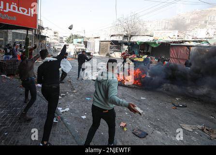 Nablus, Gaza. 22. Februar 2023. Palästinenser werfen Steine auf Fahrzeuge der israelischen Armee während eines Überfalls in der besetzten Stadt Nablus im Westjordanland, am Mittwoch, den 22. Februar 2023. Laut dem palästinensischen Gesundheitsministerium wurden am Mittwoch mindestens 10 Palästinenser getötet und Dutzende verwundet, während 102 Menschen verletzt wurden, wobei 82 von lebender Munition getroffen wurden. Sechs waren in kritischem Zustand. Foto: Mohammad Tamim/UPI Credit: UPI/Alamy Live News Stockfoto