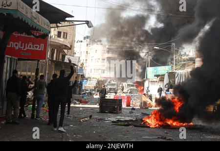 Nablus, Gaza. 22. Februar 2023. Palästinenser werfen Steine auf Fahrzeuge der israelischen Armee während eines Überfalls in der besetzten Stadt Nablus im Westjordanland, am Mittwoch, den 22. Februar 2023. Laut dem palästinensischen Gesundheitsministerium wurden am Mittwoch mindestens 10 Palästinenser getötet und Dutzende verwundet, während 102 Menschen verletzt wurden, wobei 82 von lebender Munition getroffen wurden. Sechs waren in kritischem Zustand. Foto: Mohammad Tamim/UPI Credit: UPI/Alamy Live News Stockfoto