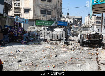 Nablus, Gaza. 22. Februar 2023. Palästinenser werfen Steine auf Fahrzeuge der israelischen Armee während eines Überfalls in der besetzten Stadt Nablus im Westjordanland, am Mittwoch, den 22. Februar 2023. Laut dem palästinensischen Gesundheitsministerium wurden am Mittwoch mindestens 10 Palästinenser getötet und Dutzende verwundet, während 102 Menschen verletzt wurden, wobei 82 von lebender Munition getroffen wurden. Sechs waren in kritischem Zustand. Foto: Mohammad Tamim/UPI Credit: UPI/Alamy Live News Stockfoto