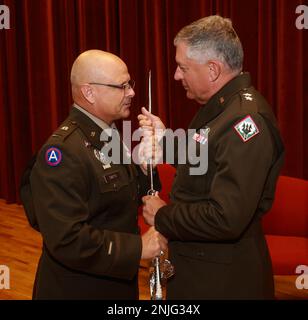 Chief Warrant Officer 5 Tommy Smith, ausscheidender Befehlshaber des Haftbefehls der Mississippi Army National Guard, übergibt ein symbolisches Schwert an Major General Janson D. Boyles, den Adjutanten General von Mississippi, während der MSARNG Command Chief Warrant Officer Change of Responsibility Zeremonie im Camp Shelby Joint Forces Training Center, Mississippi, 7. August 2022. Das Schwert bedeutet, dass Smith nach mehr als vier Jahren in seiner Position seine Verantwortung als oberster Anwaltsvollstrecker der Mississippi Nationalgarde aufgibt. Stockfoto